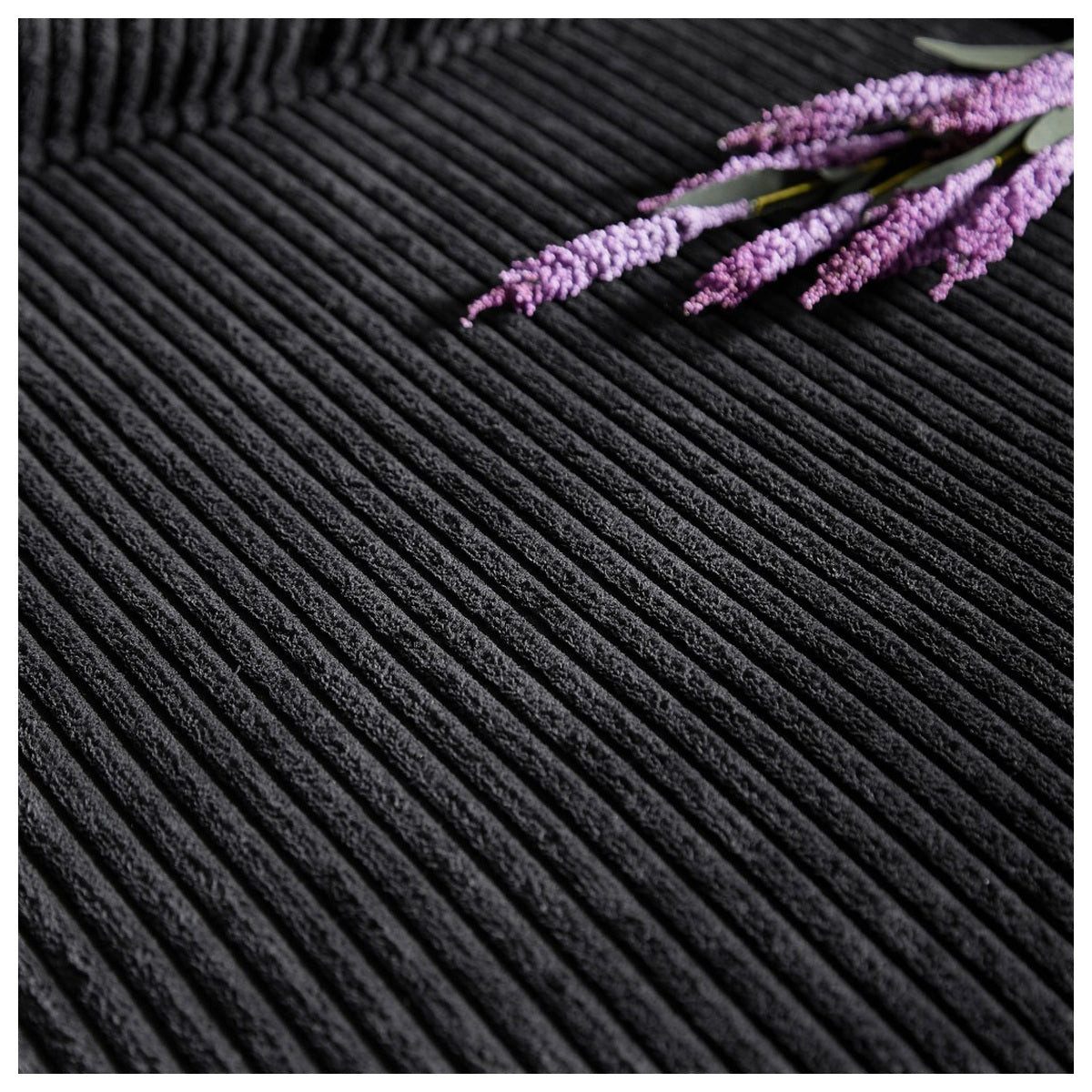 Detailansicht der Armlehne in schwarzem Cord