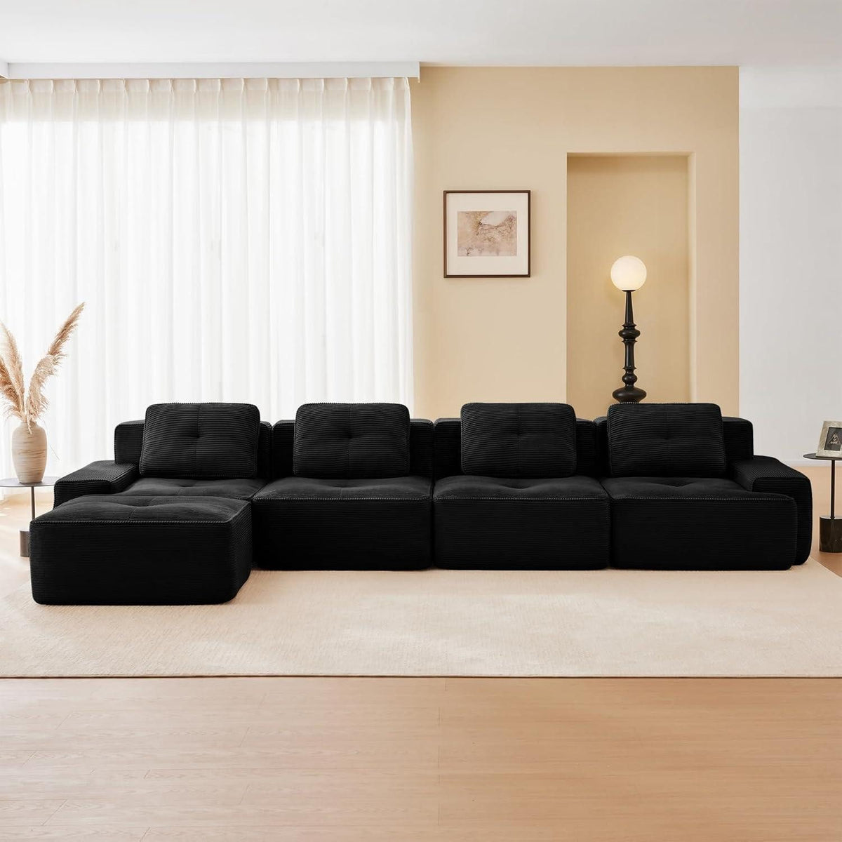 Seitenansicht des schwarzen Cord Ecksofas mit breiten Armlehnen